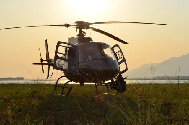 Helicopter silhouetted against a golden sunset