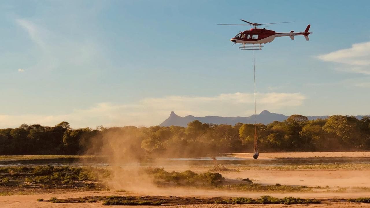 Helicopter transporting a water bucket on a longline operation
